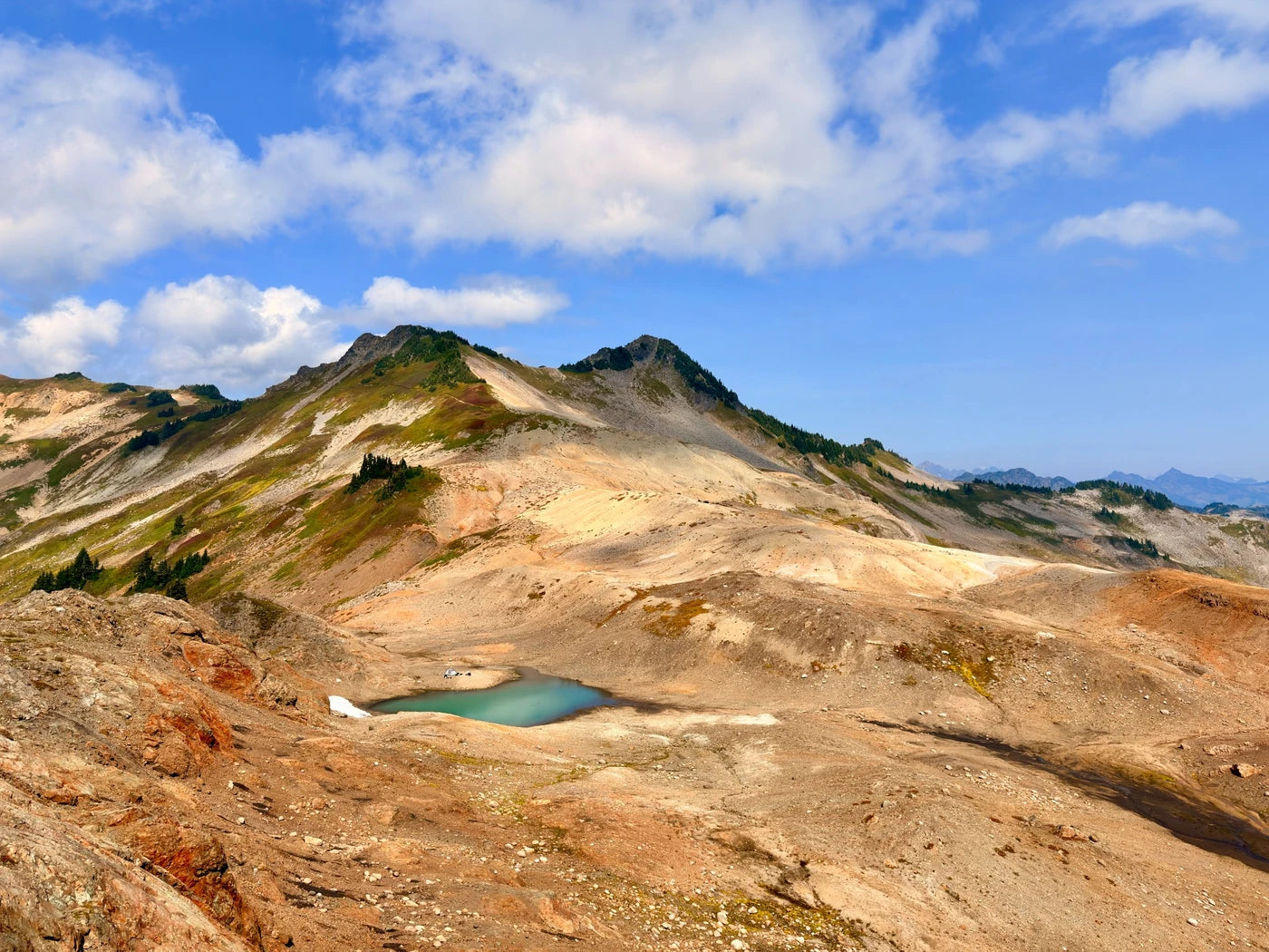 Alpine lake surrounded by sunlit mountain ridges