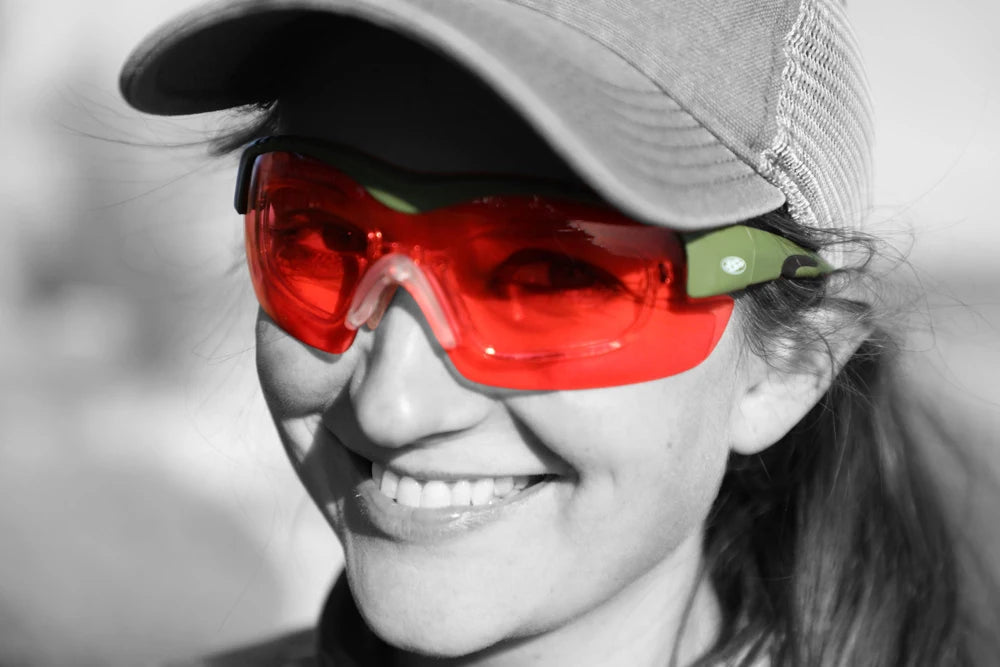 Smiling woman wearing green Methow frames with red lenses