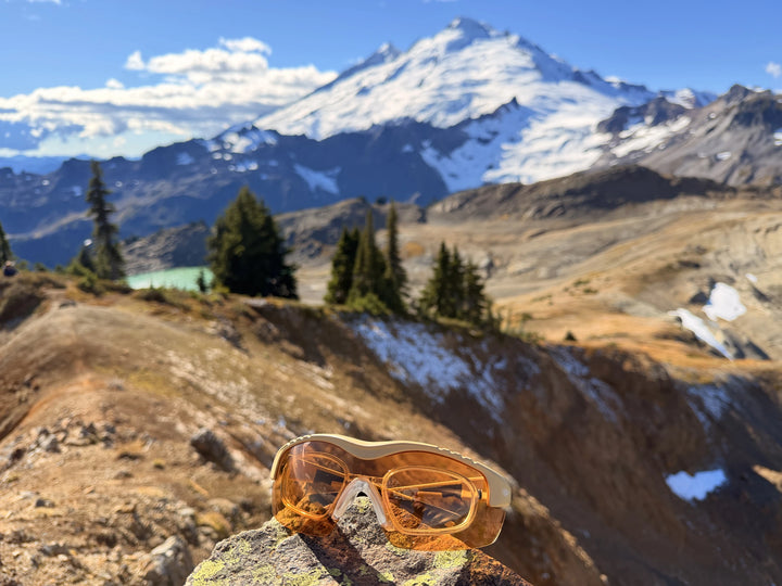 SSP Methow glasses in sharp focus on a rock with a snow-covered mountain behind them