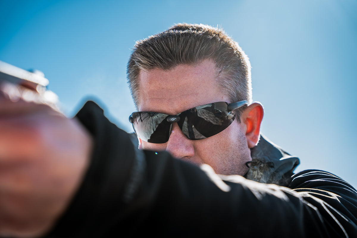 Shooter wearing Top Focal eyewear while aiming at an outdoor range.
