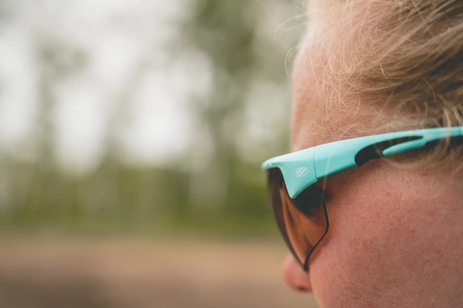 Teal Methow eyewear shown up close on a woman outdoors