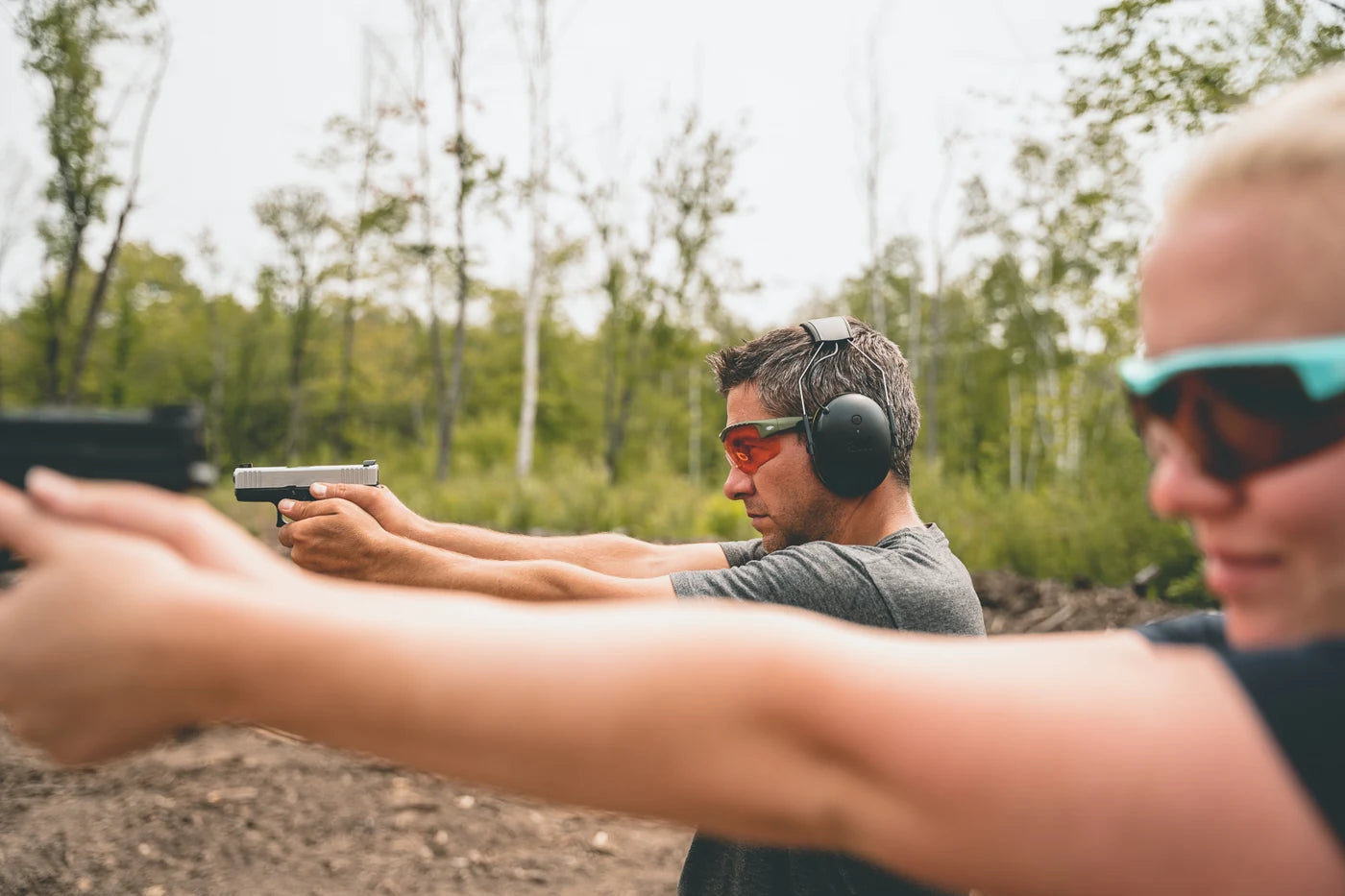 Side view of people wearing Methow eyewear at a pistol range