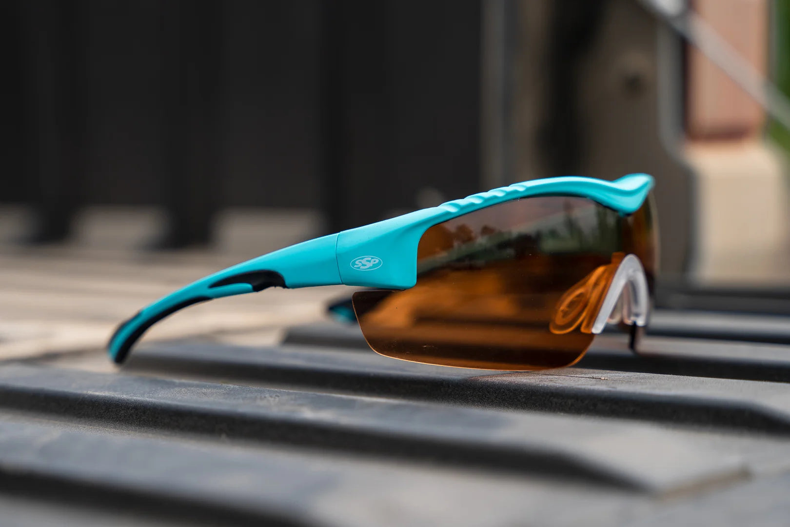 Teal Methow frame with amber lens, photographed on a truck bed